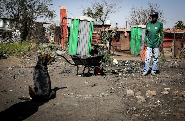 19 August 2019: A man and his dog are seen cleaning the filth around his shack.