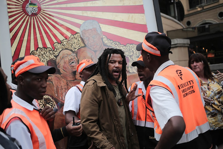 Controversial artist Ayanda Mabulu argues with security at Sandton Square in Johannesburg after erecting one of his artworks showing Jacob Zuma and Nelson Mandela in the shopping centre.