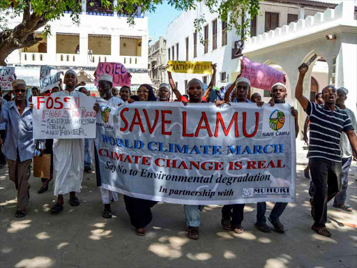 Residents hold placards as they gather in a protest against government plans to build East Africa’s first coal plant in the coastal town of Lamu, December 6, 2016. /THOMSON REUTERS FOUNDATION