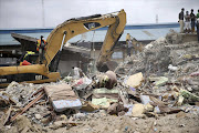 Beds used by guests are seen near an excavator at the site of the collapsed Synagogue Church of All Nations in the Ikotun-Egbe neighbourhood of Nigeria. Picture Credit: Reuters