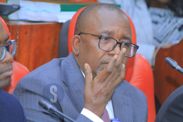 Agriculture Cabinet Secretary Mithika Linturi adjusts his spectacles as he follows proceedings during his impeachment pre-trial hearing by the National Assembly select committee at County Hall on May 7, 2024.