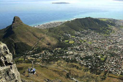 A view of the cablecar, Lion's Head, Signal Hill and Cape Town from Table Mountain with Robben Island in the distance. File photo