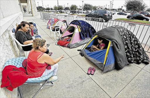 WILLING SACRIFICE: Members of the Vazquez family sit outside their tents along with others people while who are camping out at a Best Buy store two days ahead Black Friday shopping in a suburb of Houston, Texas in Rosenberg, Texas, USA, 25 November 2015this week. Retailers in the US nited States have long see the the Friday after Thanksgiving, known as Black Friday, as an the single biggest sales opportunity of the year