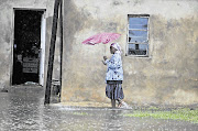 Nombuso Nene, a resident of Amauti, near Nanda township, north of Durban, walks to her house yesterday. It was one of many flooded after a tropical storm hit KwaZulu-Natal Picture: TEBOGO LETSIE