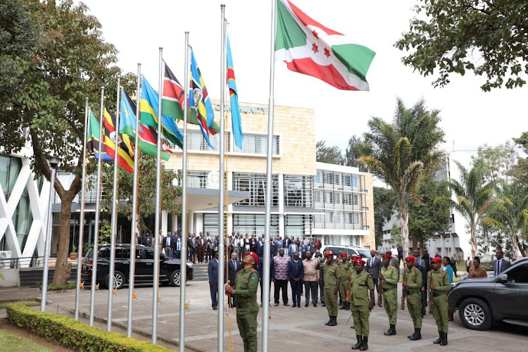 A security official raises DRC's flag at at the EAC headquarters in Arusha, Tanzania