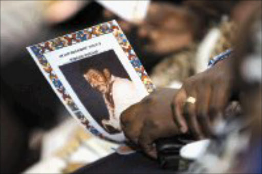 CARING: A family member holds the programme for Sam 'Bra Darkie' Williams' memorial service, held at Baseline, in Newtown, Johannesburg. The acting died of diabetes. Pic. Thobeka Ndabula. 28/02/07. © Sowetan.