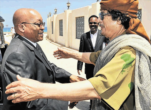 President Jacob Zuma is greeted by Muammar Gaddafi in Tripoli in 2010. 'Brother Leader's' money man, Bashir Saleh - who is on Interpol's wanted list - is in the background