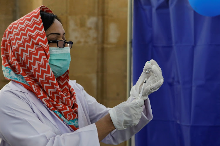 A paramedic prepares a dose of Sinopharm's Covid-19 vaccine before administering it to a health worker at a vaccination centre in Karachi, Pakistan on February 11 2021.