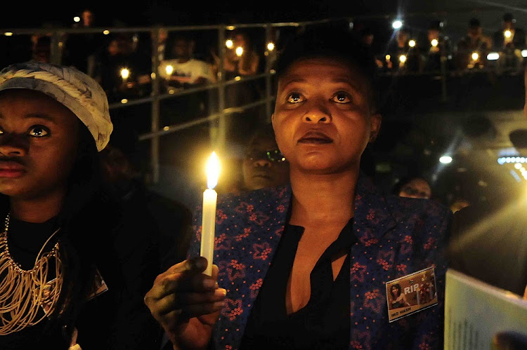 FILE PICTURE: Actress Manaka Ranaka holds up a candle during the memorial service of transgender celebrity and stylist Iko Mash.