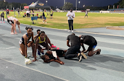 Prudence Sekgodiso, in the yellow vest, looks up after congratulating exhausted teammate Kethobogile Haingura after he had won the men's 800m in an Olympic qualifying time. Sekgodiso had won the women's race not long before. 