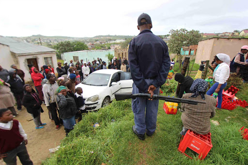 SAFE FOR NOW: Armed police stand guard while foreign shop owners try to salvage what is left after looters went on the rampage in Grahamstown yesterday Picture: DAVID MACGREGOR