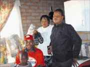 FINE PRESENTS: Mama Angel paid a visit to Lehae village to present goodies to the Lamula family. Pictured here are, standing, Phumzile Lamula and her son Sibusiso, and Sowetan's Lindi Obose with little Themba. © Sowetan.