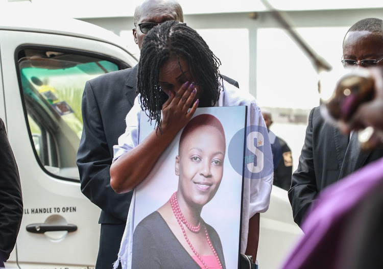 Sister to the late Journalist Rita Tinina gets emotional as she holds a memorial portrait at Holy Family Basillica, Nairobi on March 25,2024