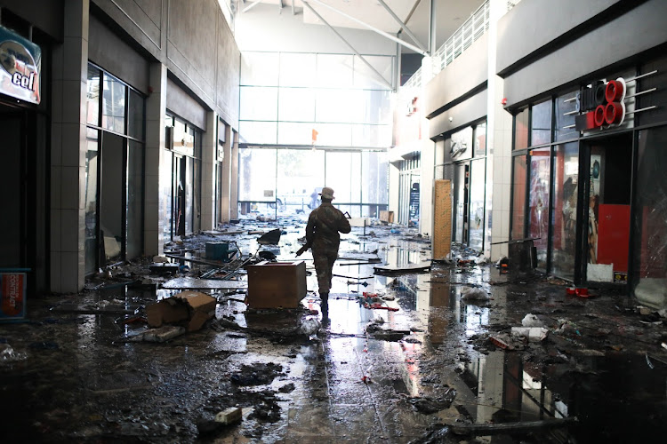 A SANDF soldier patrols a looted mall In Alexandra, Johannesburg, in this file photo from July.