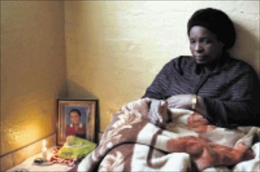 TRAGEDY: Sebenzile Sithole mourns her daughter Thabisile, 13, (framed photo) who was raped and then killed. 18/04/09. Pic. Thuli Dlamini. © Sowetan.