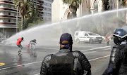 Police disperse  Nehawu members using a water canon and stun grenades in front of parliament during their nationwide strike over public servant’s salaries and providing personal protective equipment for health and frontline workers. 
