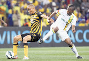 Siyabonga Nkosi of Kaizer Chiefs moves the ball away from Thamsanqa Sangweni of Mamelodi Sundowns during their Premiership match at Soccer City last night. Amakhosi won 2-1