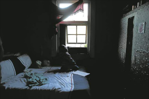 Cerebral palsy sufferer Okuhle, 7, sits next to the window of a room he shares with his mother in Southernwood. The boy cannot walk or talk. Picture: MARK ANDREWS