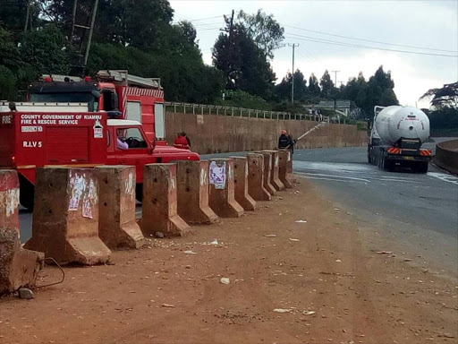 A fire fighter sprays water on a truck carrying liquefied petroleum gas along Waiyaki Way near Kikuyu, June 21, 2017. /COURTESY