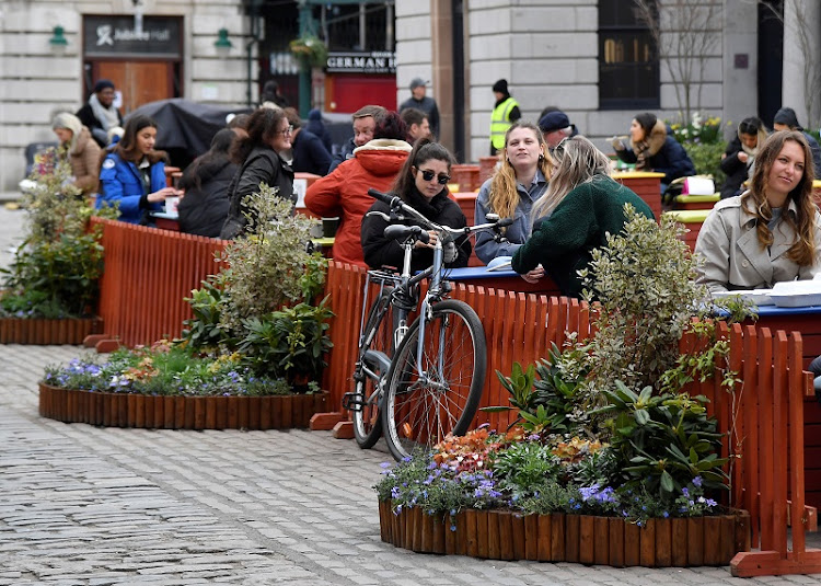 People socialise in a socially distanced outdoor seating area in Covent Garden, London, on April 6 before a further easing of lockdown restrictions for England on April 12.