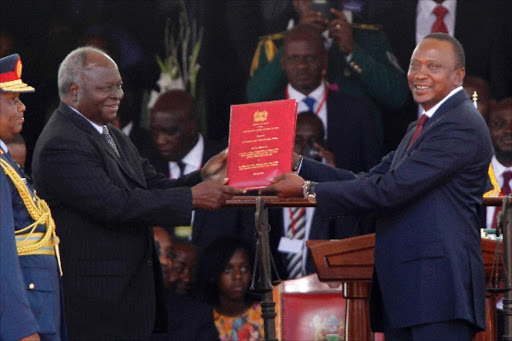 Outgoing President Mwai Kibaki hands over power to new President Uhuru Kenyatta at Kasarani, Nairobi, on April 9, 2013. Kibaki helped Mau Mau come out of the woodwork, while Uhuru oversaw the release of a report addressing historical injustices that had plagued Kenya since Independence and boiled over in 2007, almost leading to civil war