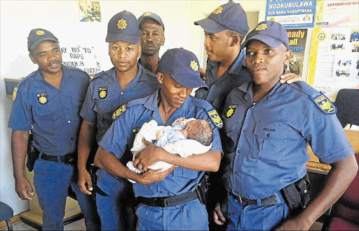 IN SAFE HANDS: The kidnapped baby girl was recovered by these members of the Mdantsane Crime Prevention Unit Picture: ZWANGA MUKHUTHU