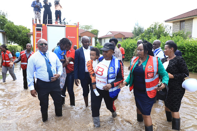 Machakos Governor Wavinya Ndeti carries a baby out of the residential estate affected by the floods in Athi River, Machakos on April 24, 2024.