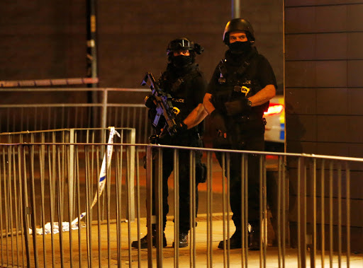 Armed police officers stand next to a police cordon outside the Manchester Arena, where U.S. singer Ariana Grande had been performing, in Manchester, northern England, Britain, May 23, 2017. REUTERS/Andrew Yates