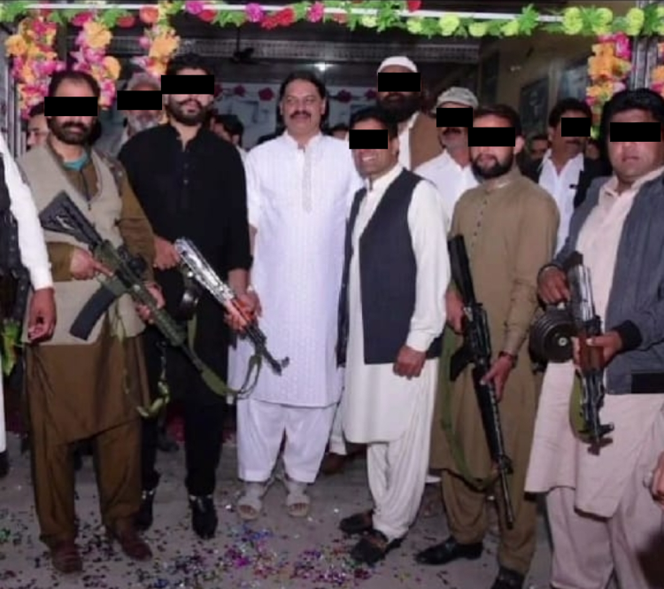 A picture taken in Pakistan of alleged kidnapping kingpin Tariq 'Baba' Tahir with his associates.