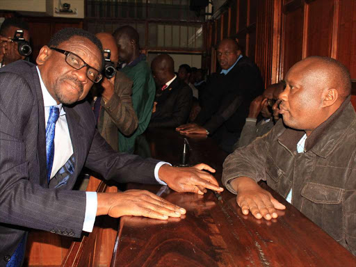 Lawyer James Orengo consults with Governor Sospeter Ojaamong at a Milimani anti-corruption court yesterday / COLLINS KWEYU