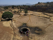A drone view of women drawing water from a well on a hot day in Kasara, India, on May 1 2024.