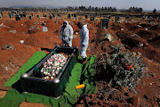 The coffin of a suspected Covid-19 victim is lowered into the ground at a cemetery in the south of Johannesburg. No family members or friends arrived for the funeral as most were overseas and could not travel to SA. 