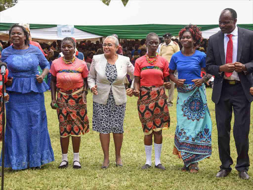 First Lady Margaret Kenyatta, Governor Zachary Obado and his spouse Hellen Obado join entertainment groups for a dance at Uriri Secondary School sports ground, Migori County during the handing-over ceremony of the 37th fully-kitted Beyond-Zero Mobile Clinic to the county government. Photo/PSCU