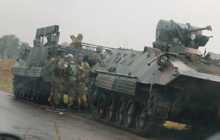 Soldiers stand beside military vehicles just outside Harare, Zimbabwe, on November 14 2017. The military and police in Zimbabwe this week launched a blitz operation to curb potential civil unrest, said presidential spokesman George Charamba.