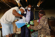 SAFETY DRIVE:  Councillor Ayanda Tyokwana and human settlements political  Andile Mfunda hand out hand sanitiser and soap to Nobengazi Sali, 60, in Area Q, Walmer Township