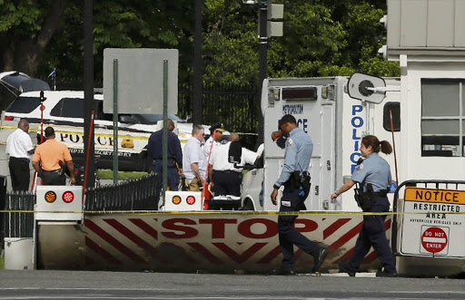 Police officers walk past the location of a shooting near a White House gate in Washington, DC, U.S. May 20, 2016. REUTERS/Jonathan Ernst