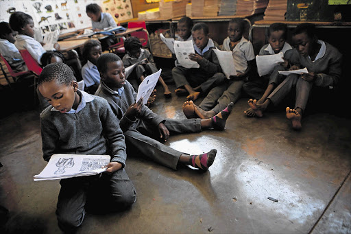 Pupils read from photocopies at Rutandale Primary School in Thohoyandou, Limpopo, in this file photo from 2012 because their textbooks had not been delivered halfway into the year.
