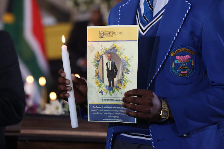 A school pupil in uniform at the mass funeral.