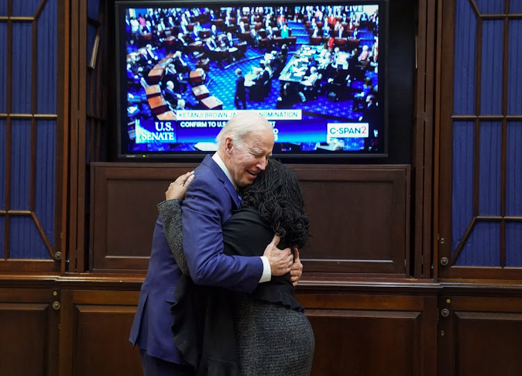 With a live Senate floor TV feed as a backdrop, US President Joe Biden embraces Judge Ketanji Brown Jackson after she received enough Senate votes to confirm her to the US Supreme Court, making her the first Black woman to serve on the Supreme Court, in the Roosevelt Room at the White House in Washington U.S., April 7, 2022.