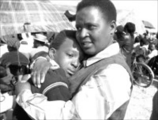 CARING ARMS: Nobuhle Gama is comforted by her teacher Elsie Mantsimbi. Pic. McKeed Kotlolo. Sowetan.