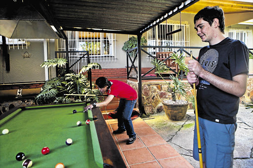 Thomas Ferreira plays a game of pool with his cousin Clive at their home in Krugersdorp, on the West Rand. Ferreira was hit by the official vehicle of a Gauteng MEC for local government and housing, Humphrey Mmemezi, last year.