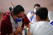 A child with an underlying condition receives a Pfizer vaccine. As of Wednesday, South African children aged 12 and up can receive a single dose.