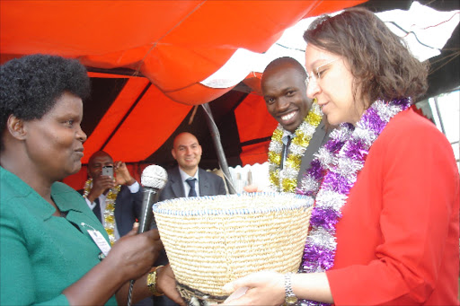 Involved: One Hen Campaign Project director Alice Gichana presents a gift to Turkish Ambassador Deniz Eke. One Hen Campaign Project Ceo James Makini and Turkish Co-operation and Coordination Agency coordinator Halil Ibrahim Okur looks on.