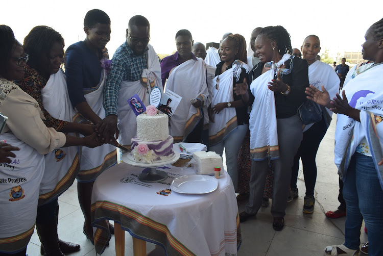 Homa Bay executive for gender Sarah Malit, MCA Paul Bari and chief officer for gender Dolphin Ochere lead in cutting a cake as they celebrate International Women's Day in Homa Bay town on March 6,2024