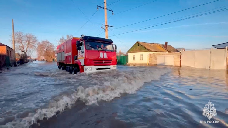 Rescuers drive in a flooded residential area in the city of Orsk, Russia, April 6, 2024, in this still image taken from video.