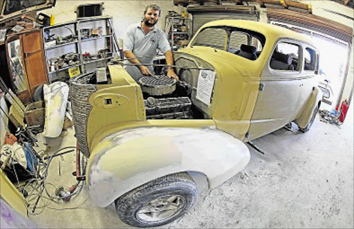 WORK IN PROGRESS: Motor car rebuilding enthusiast Leslie Thomas tinkers on his 1938 Chevrolet ahead of the 12th Wizards on Wheels Car show which will be held on Saturday at the Port Rex Technical High School Picture: ALAN EASON