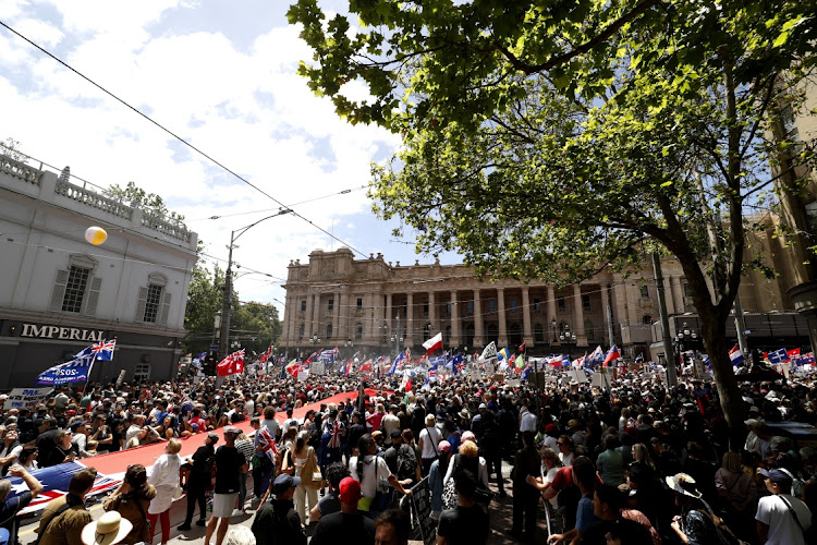 Protesters gather on the steps of Parliment House November 27, 2021 in Melbourne, Australia. People gathered in Melbourne to protest against mandatory vaccination. The country has banned travellers from SA, Namibia, Zimbabwe, Botswana, Lesotho, Eswatini, the Seychelles, Malawi and Mozambique following emergence of a new Covid-19 variant in Southern Africa.