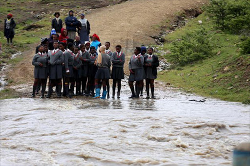 DON’T FENCE ME IN: Pupils in Qaga village in King William’s Town are trapped by the raging stream, which has flooded the bridge Picture: SIBONGILE NGALWA