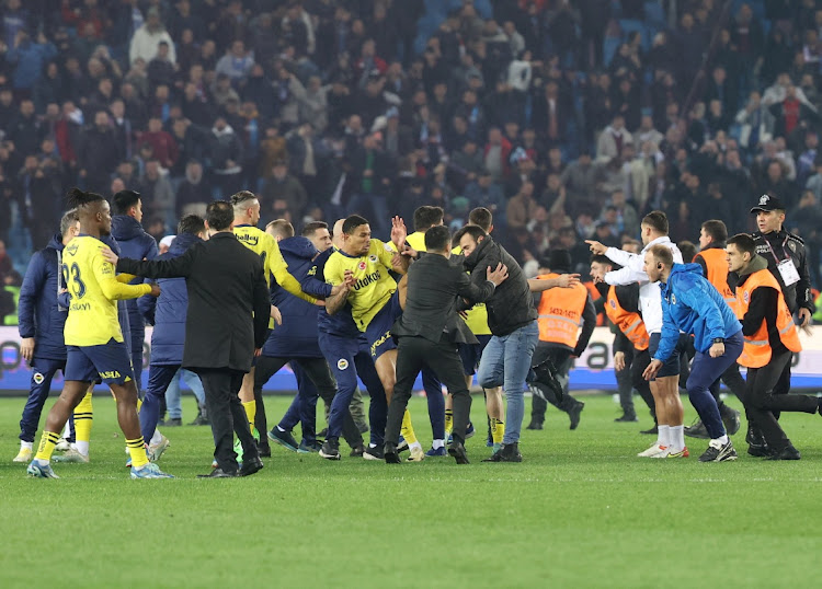 Trabzonspor fans invade the pitch and clash with Fenerbahce players and security staff after the Turkish Super Lig match against Trabzonspor at Papara Park in Trabzon, Turkey on Sunday.