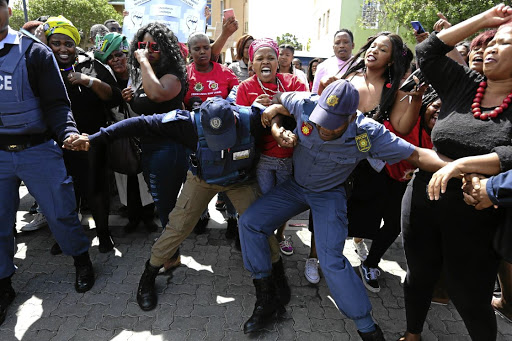 Police officers had their hands full yesterday as supporters for and against controversial televangelist Timothy Omotoso clashed outside the Port Elizabeth high court.